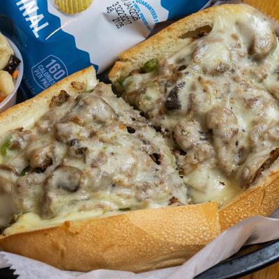 Philly cheesesteak sandwich with mushrooms and melted cheese.