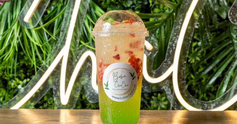 Kiwi Soda with strawberry fruit in a branded cup