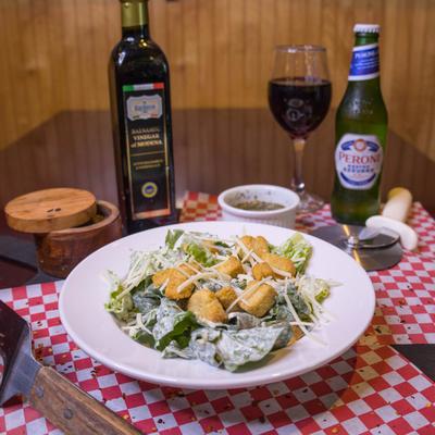 Caesar salad served with drinks and condiments.