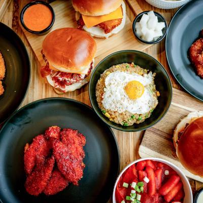 Korean fried chicken tenders with Fire Bird spicy flavors, chicken sandwiches, and a bowl of veggie fried rice.