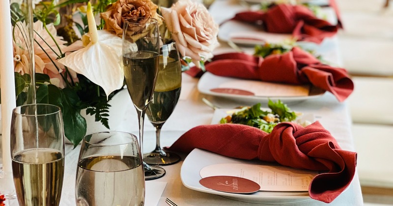 Elegant wedding table setting with, glassware, flowers, and red napkins