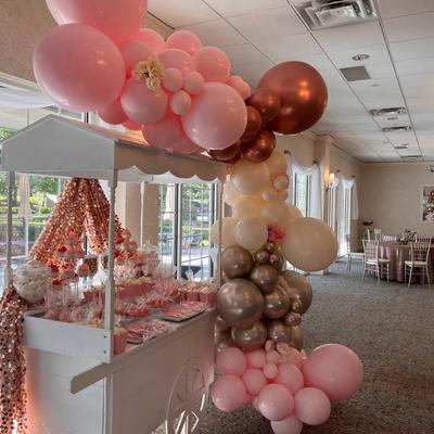 Interior, a  baby-shower cart decor with pink, white,  gold, and sliver balloons