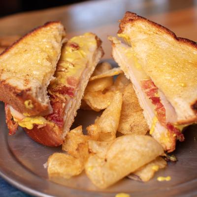 Lakeside sandwich and chips on a metal plate.