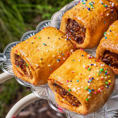 Italian fig cookies topped with colorful sprinkles on a glass tray.