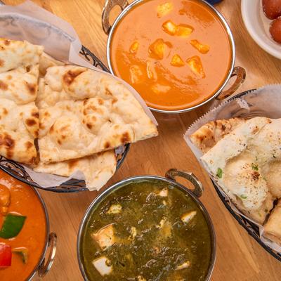 Assorted bowls of curry and naan.