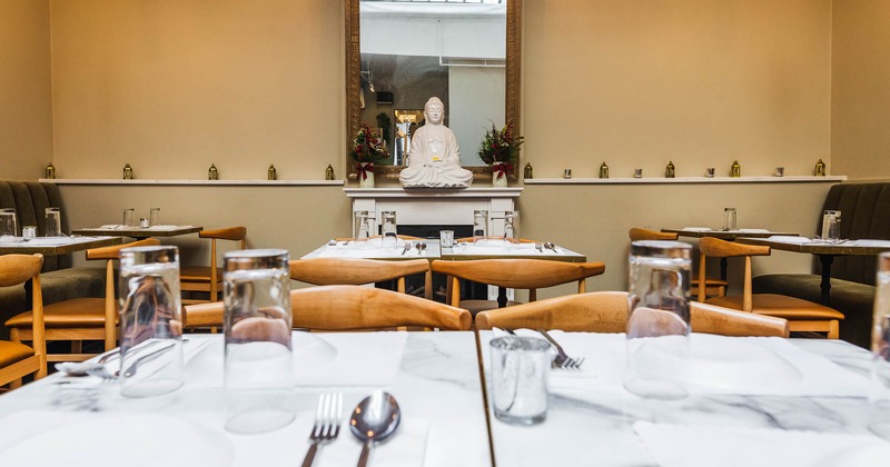 Interior detail with tables set for guest and mirror on the wall
