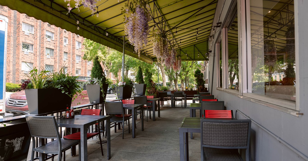 Exterior, covered seating area,  tables for two, hanging flower pots as a decoration