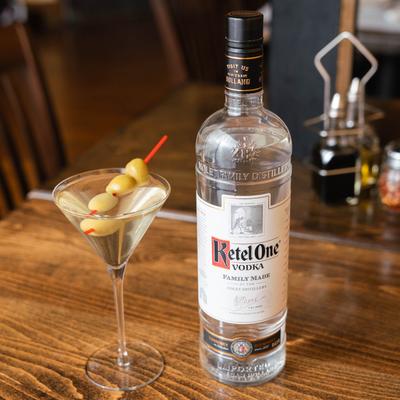 A served martini and a bottle of vodka.