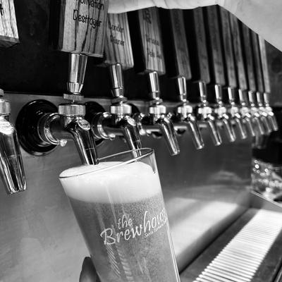 Black and white photograph of pouring beer from the tap.