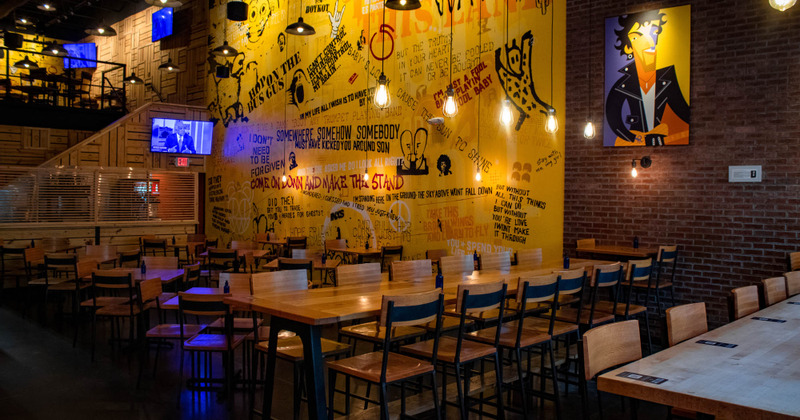 Interior, seating area and a wall decorated with a prited graffiti-like with quotes and musicians