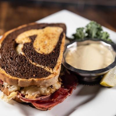 Reuben sandwich with sauce on the side.