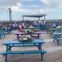 A wedding ceremony organized in an open air seating area.