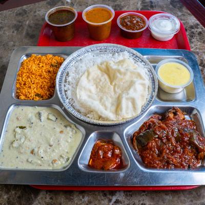 A dish of rice cooked in boiling milk with side dishes and chutneys.