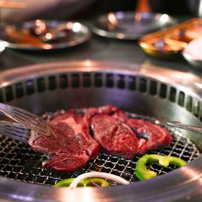 Ribeye steaks, green bell peppers and onion on the grill