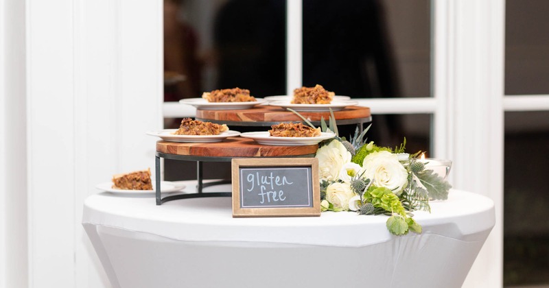 Outside, gluten free pies on a high cocktail table with floral decoration