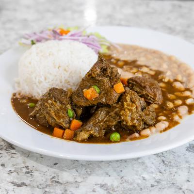 Peruvian beef stew accompanied by rice and beans.