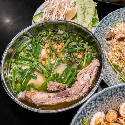 Vietnamese street noodles, surrounded by other food dishes.