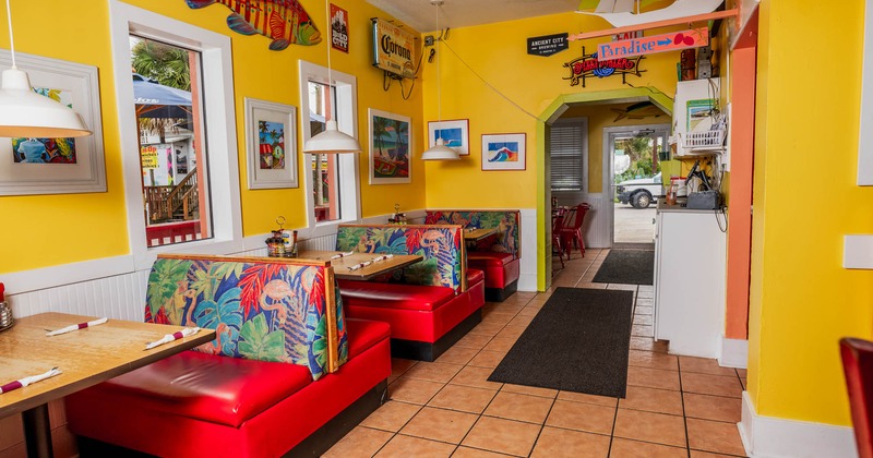 Interior, seating booths with tables, various Caribbean motif decoration, tile flooring