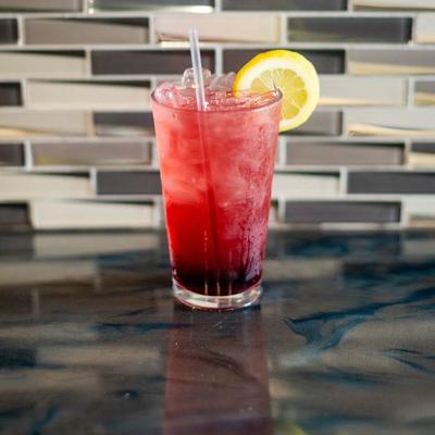 A refreshing red drink garnished with a lemon wedge.