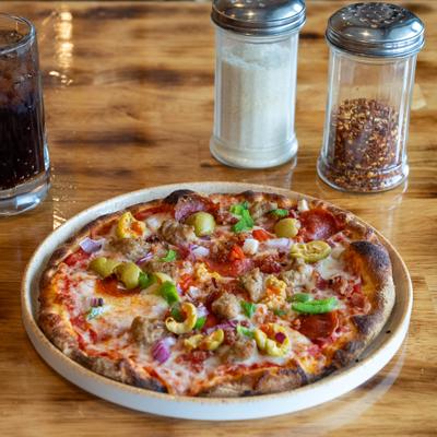 Supremo Pizza with pepperoni, bacon, sausage, bell peppers, onions and green olives.