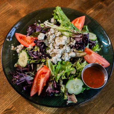 House salad with mixed greens, Gorgonzola crumbles, and a tomato vinaigrette.