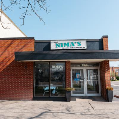 Nima's Pizzeria restaurant entrance beneath a clear blue sky.