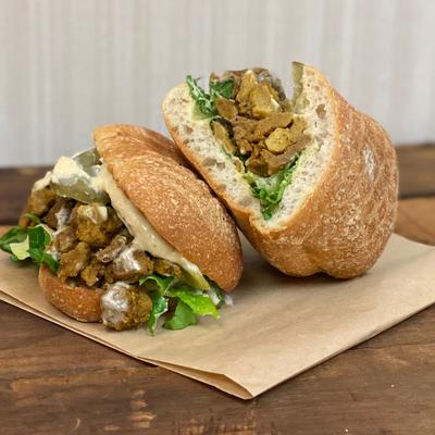 Chicken sandwich featuring grilled chicken, fresh greens and a creamy dressing.