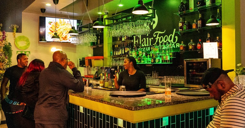 A bar with a bartender and a guest standing