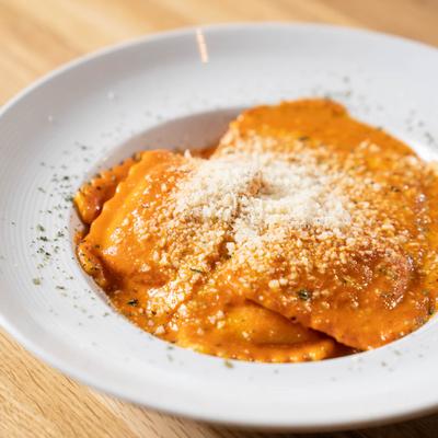 Four Cheeses Ravioli in a pink vodka sauce, with Parmesan on top.