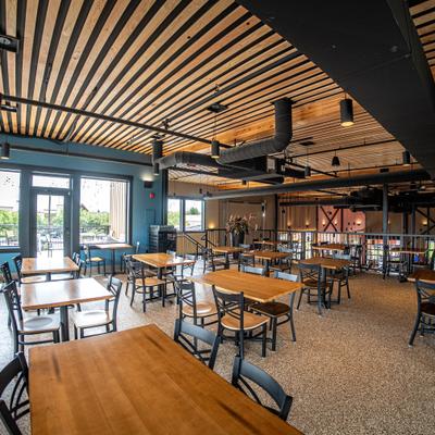 Dining area featuring a distinctive slatted wooden ceiling and table seating.