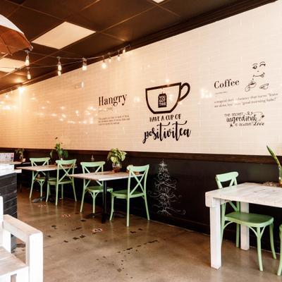 Cafe interior with tables, chairs and wall text decor.