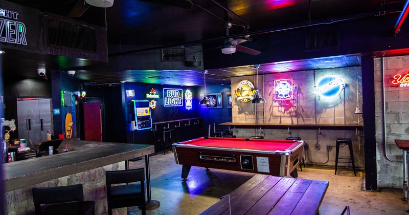 Interior, bar area with a pool table and neon lights on walls