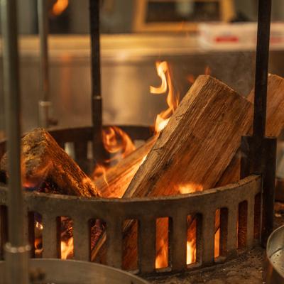 Burning logs glowing inside a metal fire basket.