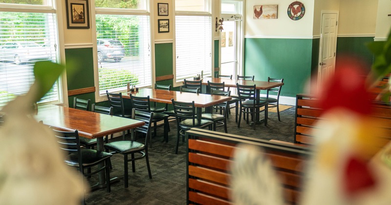 Interior view of a restaurant with wooden tables and black chairs