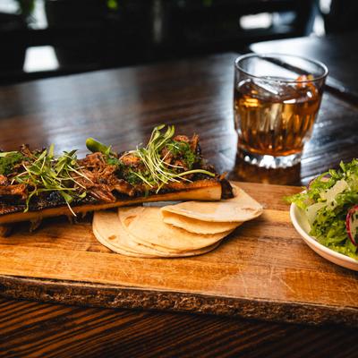 Roasted bone marrow served with a salad and tortillas.