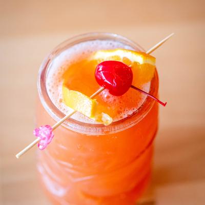 Mai Tai cocktail gaenished with a orange slice and a cherry on a pick.