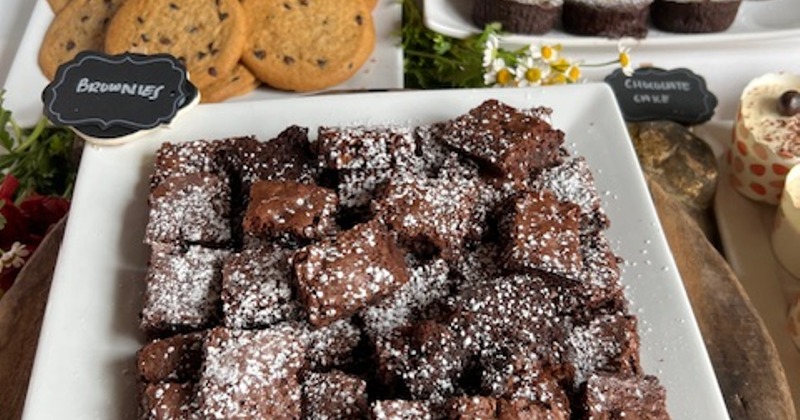 Assorted cakes, cookies and a plate of brownies on a buffet table