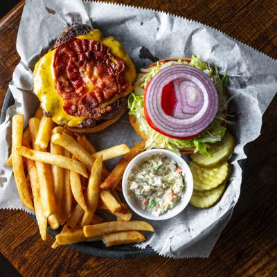 Nino's Burger served with fries and coleslaw, top view.