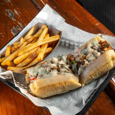 Chicken Philly Cheesestaek sandwich served with fries.
