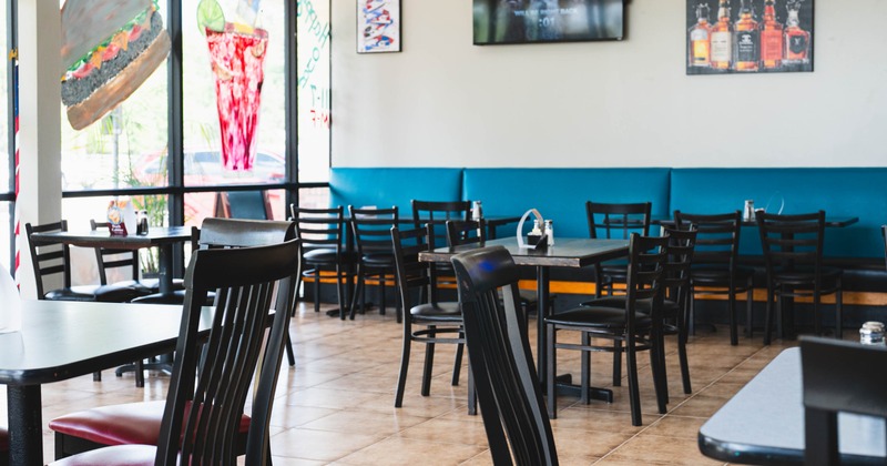 Casual interior - black tables and chairs, teal bench seating and wall art.