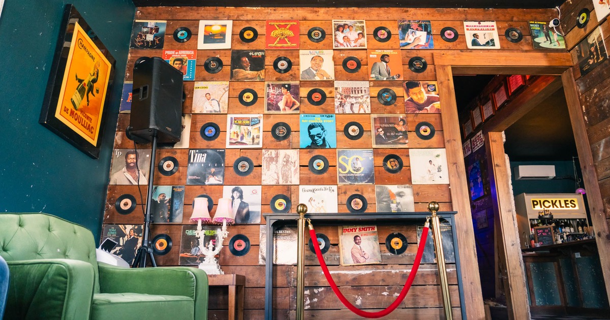 Wall adorned with vintage vinyl records and framed album covers in a cozy room