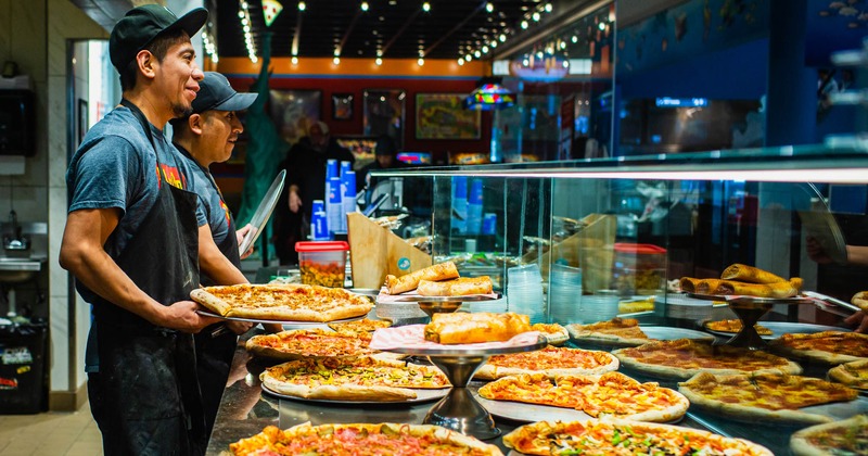 Restaurant staff and different pizzas