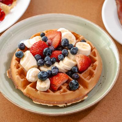 Waffle with berries, banana, and whipped cream.