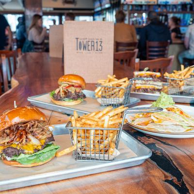 A table set with dishes, Reef burger, high tide burger, patty melt, chicken quesadilla.