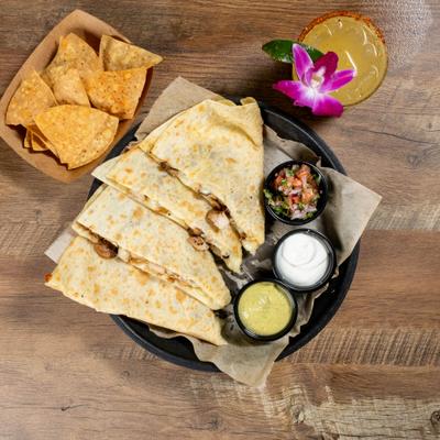Quesadilla served with guacamole, sour cream, pico de gallo, tortilla chips, and margarita.