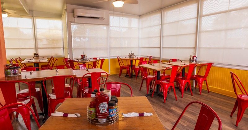 Interior, dining area, tables and chairs ready for guests, condiment trays on the tables