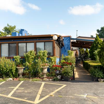 The exterior of Ari's Restaurant & Bar decorated with greenery.