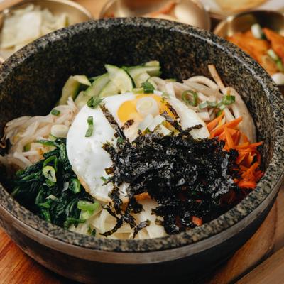 Bibimbap topped with seasoned vegetables, fried egg and roasted seaweed.