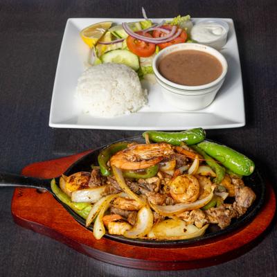 Chicken, shrimp, and steak Fajitas, served with salad, rice, and beans.
