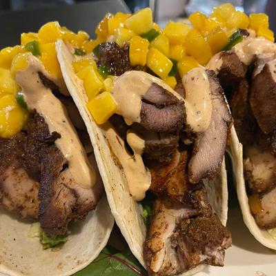 Jerk Chicken Tacos topped with mango salsa and chipotle ranch.